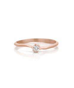 Handmade engagement ring in rose gold with odd, matte surface and one diamond.