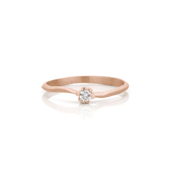 Handmade engagement ring in rose gold with odd, matte surface and one diamond.