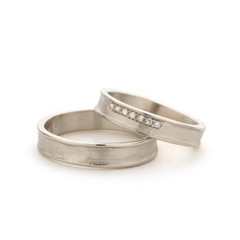 Organic timeless wedding rings with white gold, matte finish, polished edges and seven tiny diamonds in the ring for ladies.