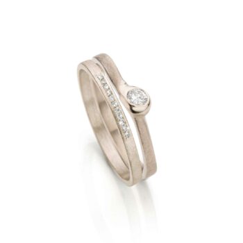 Elegante combinatie in roségoud met grote diamant in de matte verlovingsring en elf kleine diamantjes in de trouwring.