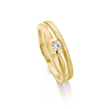 Organische gouden combinatie met matte afwerking en oneven gepolijste randen en diamant in de verlovingsring.
