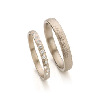 Unique white gold wedding rings with organic dents and eleven diamonds.