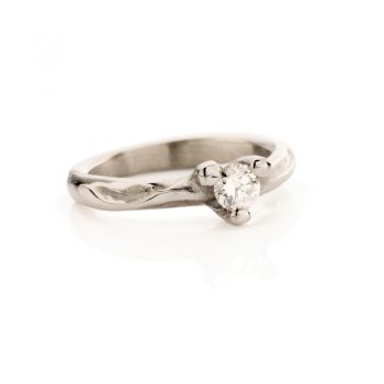 Betoverende witgouden verlovingsring met organisch lopende matte en gepolijste details en een diamant in een gepolijst sluitstuk.