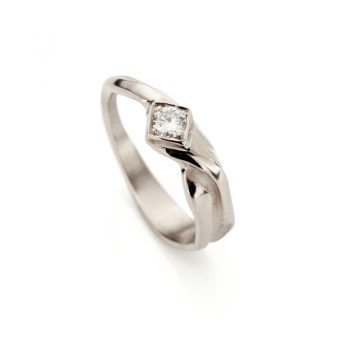 Refined white gold engagement ring with a polished finish, matte details, and a brilliant diamond in a diamond-shaped centerpiece.