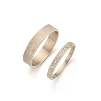 Champagnekleurige trouwringen van Ines Bouwen, handgemaakt met speelse texturen en diamanten.
