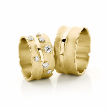 Special golden wedding rings with seven large diamonds in the women's ring and polished scrolled edges.