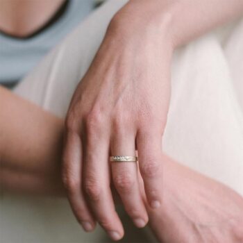 Graceful organic white gold wedding rings with matte finish and six diamonds in the ladies ring.