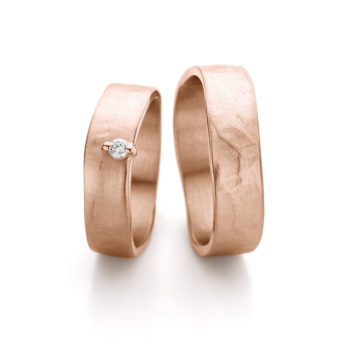 Wide elegant rose wedding rings with matte finish, polished edge and dainty diamond in ladies ring.