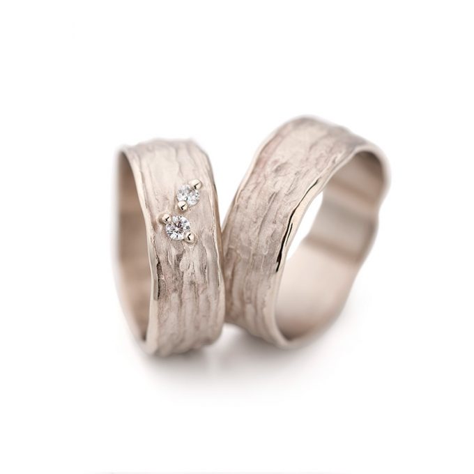 Natural white gold wedding rings with uneven surface and polished irregular edges.