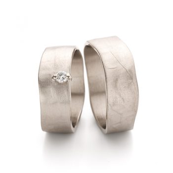 Wide white gold wedding rings with a diamond in the ring for ladies.