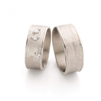 Timeless simple wedding rings with wide matte surface, polished edges and two diamonds on the ring for ladies.